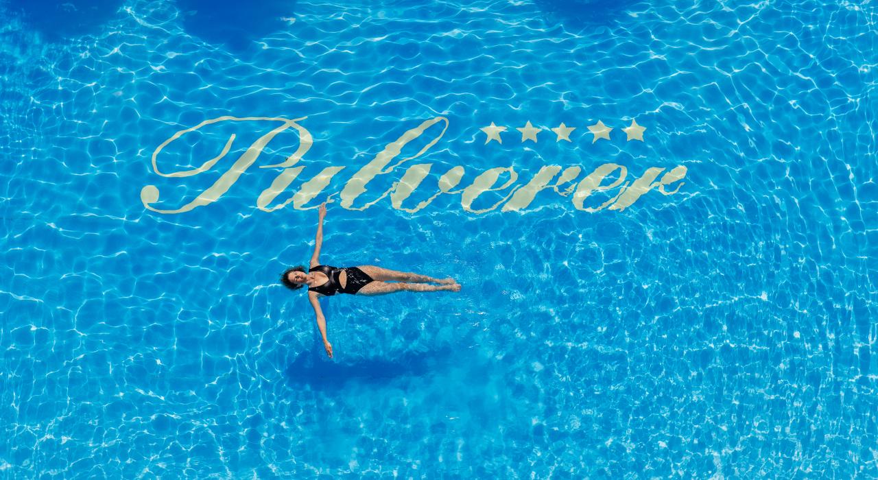 Luftaufnahme einer auf dem Rücken schwimmenden Frau im Außenpool des Thermenhotels in Kärnten