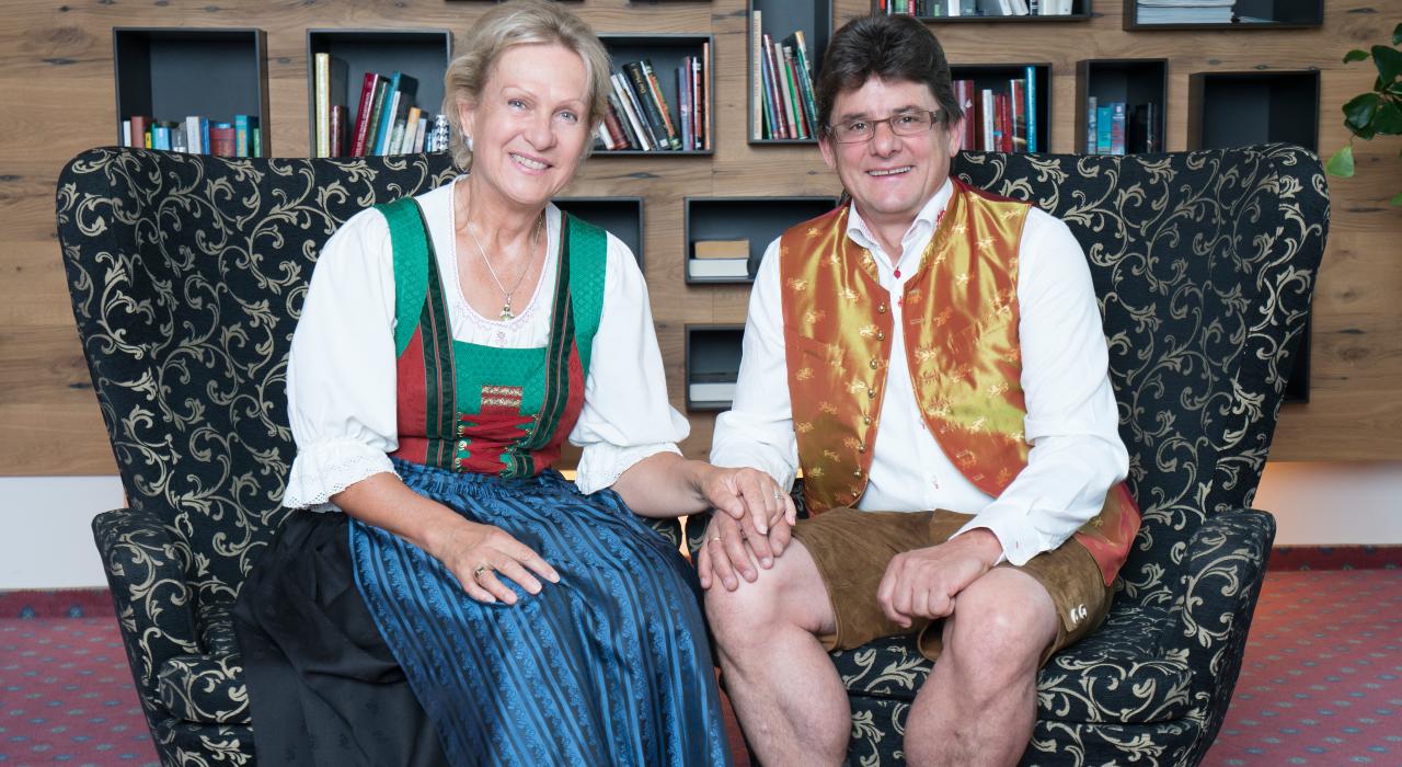Frau und Herr Pulverer angezogen in Tracht, lächeln in die Kamera
