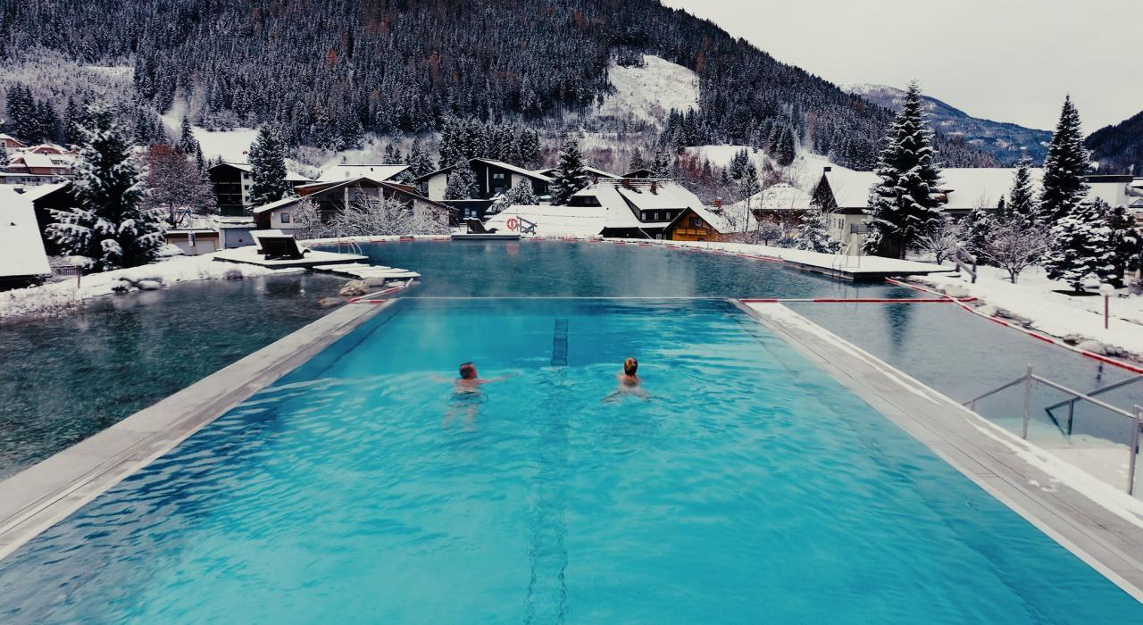 Gast im Infinitypool blickt auf Kärntner Bergwelt