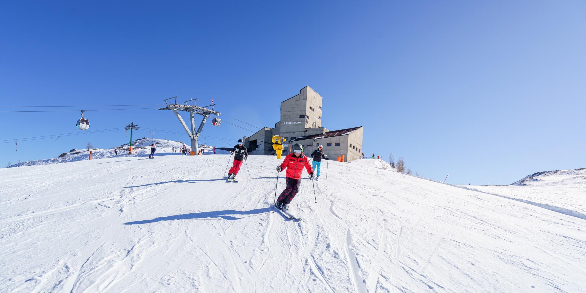 Menschen beim Skifahren in den Bergen während des Winterurlaubs in Kärnten