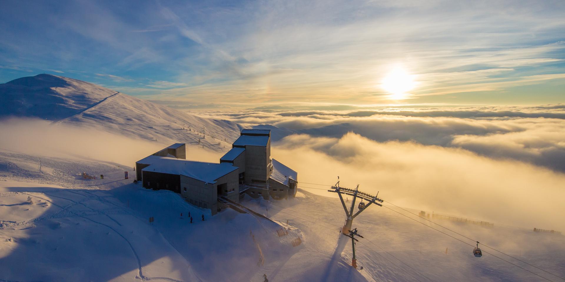 Ein Foto vom Gipfel der Berge auf der Skistation und der Himmel bedeckt mit Wolken und Sonnenschein, perfekt für einen Winterurlaub in Kärnten