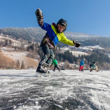 Ein Junge beim Schlittschuhlaufen im Winterurlaub in Kärnten