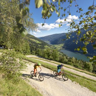 Zwei Personen beim Mountainbiken in Bad Kleinkirchheim genießen den Blick auf den See und die Natur