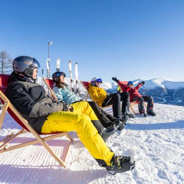Vier Personen entspannen sich auf Stühlen nach dem Skifahren im Familienurlaub in unserem Hotel in Bad Kleinkirchheim
