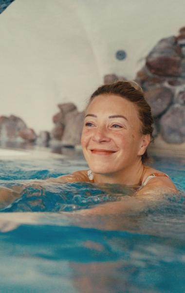 Frau entspannt im Innenpool des Hotels Pulverer