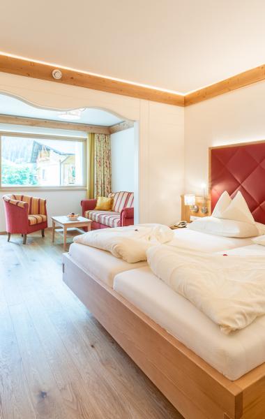 Blick auf ein Bett und eine Sitzecke im Zimmer des 5 Sterne Hotels in Bad Kleinkirchheim