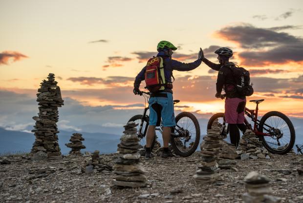 Zwei Personen, die beim Mountainbiken in Bad Kleinkirchheim auf dem Berg abklatschen