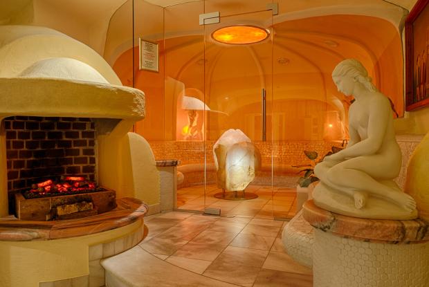 Ein Blick in die Sauna mit Statuen und Glastüren in der Thermenwelt Hotel Pulverer