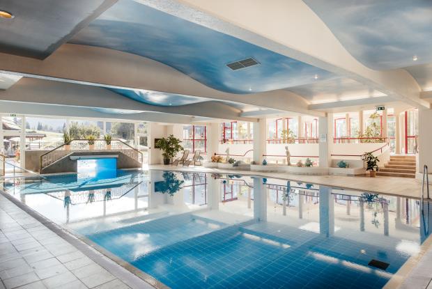 Der großzügige Innenpool mit großen Fenstern und Liegestühlen im 5-Sterne-Hotel in Bad Kleinkirchheim