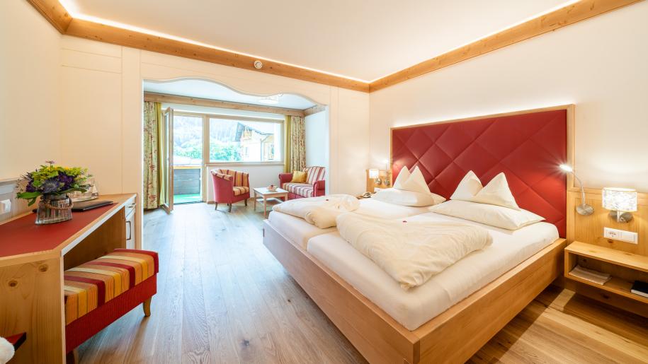 Blick auf ein Bett und eine Sitzecke im Zimmer des 5 Sterne Hotels in Bad Kleinkirchheim